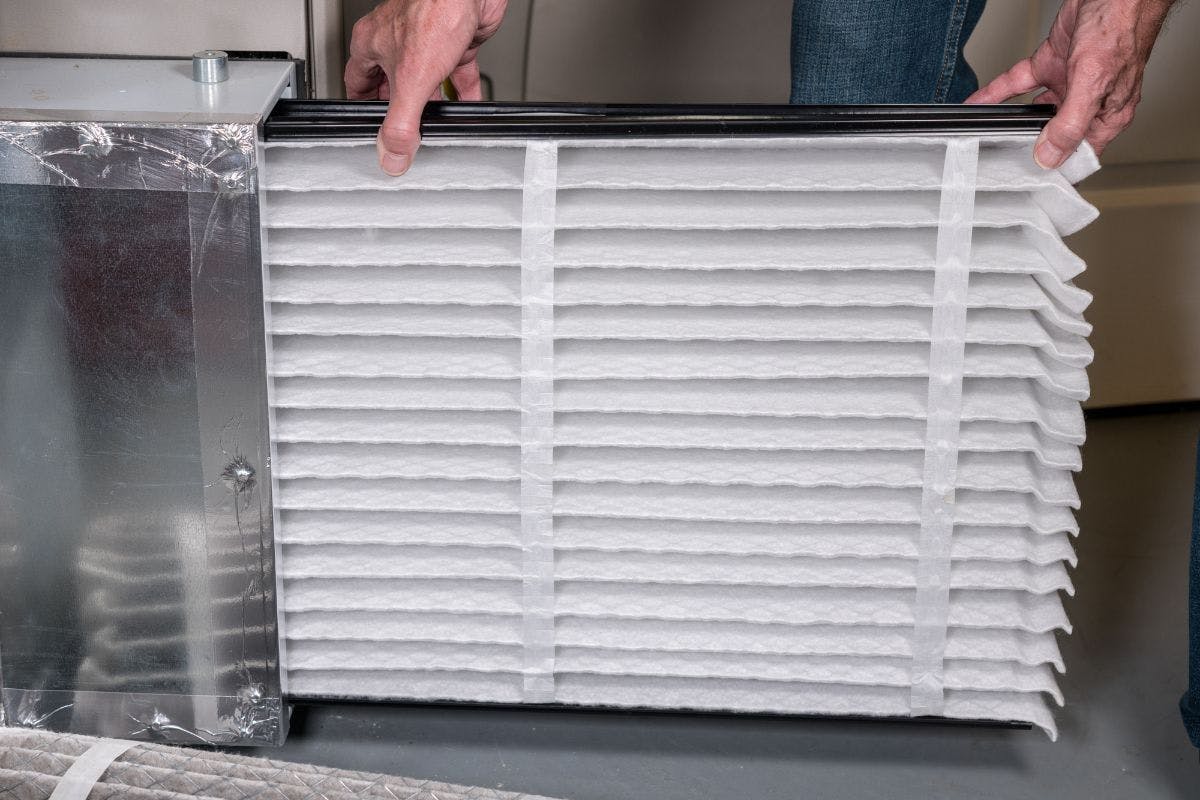 Installing a clean HVAC air filter.
