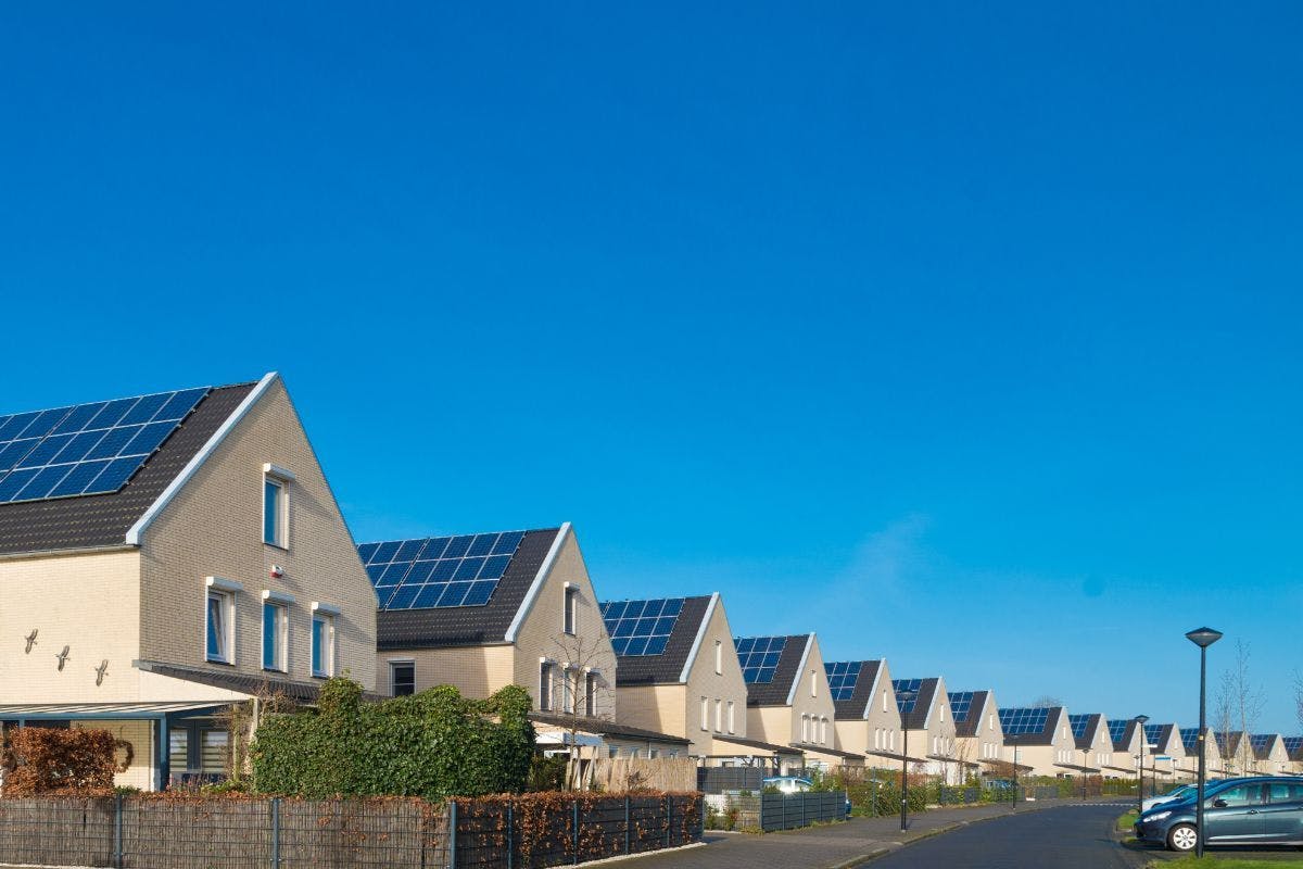 A row of identical homes with solar panels on the roof.