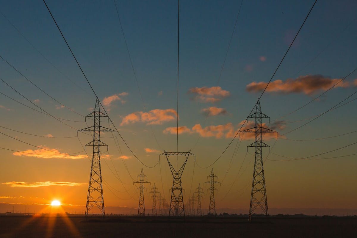 Power lines seen with the sun low on the horizon.