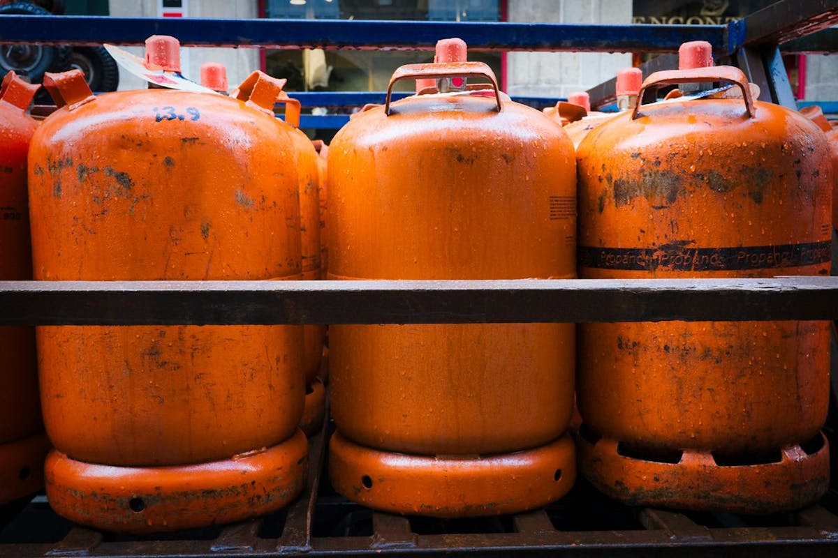 Orange propane tanks lined up in rows.