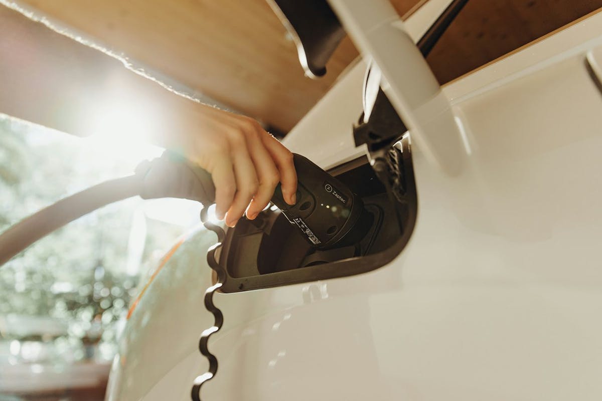 An ev charger plugged into a white car.