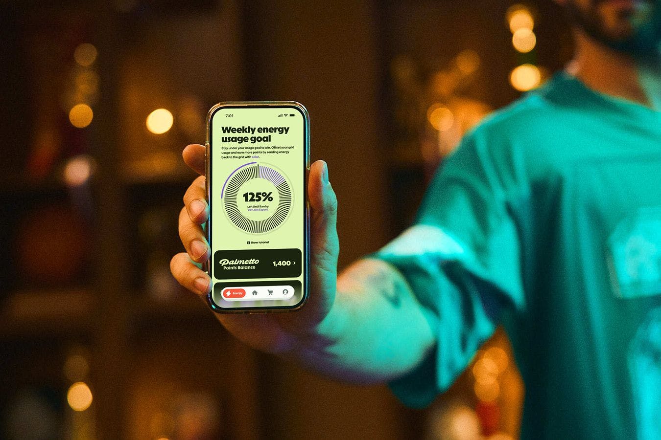 A person with their arm extended toward the camera holding a smart phone showing the Palmetto App.