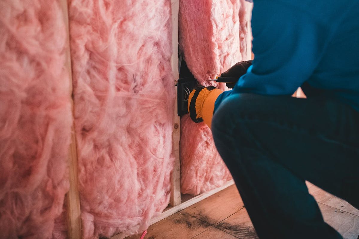 Installing insulation between wall joists.