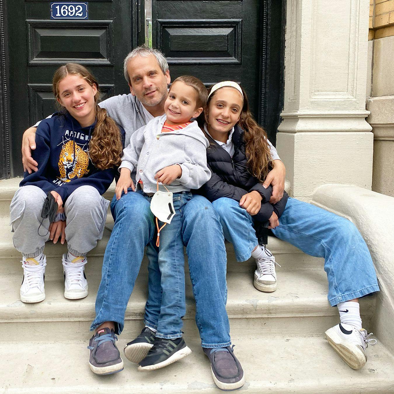 Eduardo Berlin and his kids on a front stoop.