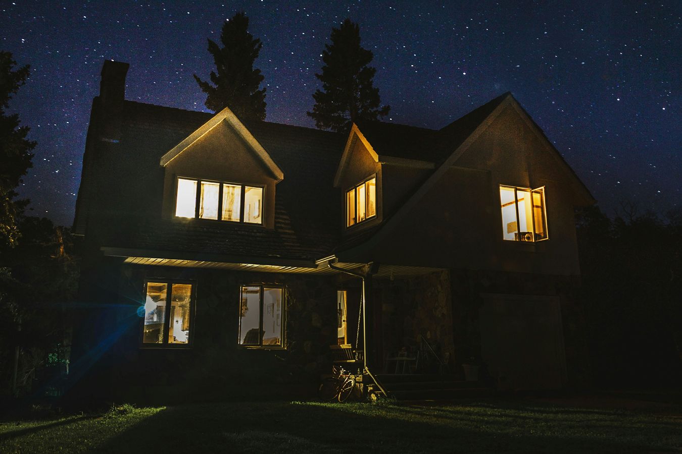 A house with its lights on in the dark.