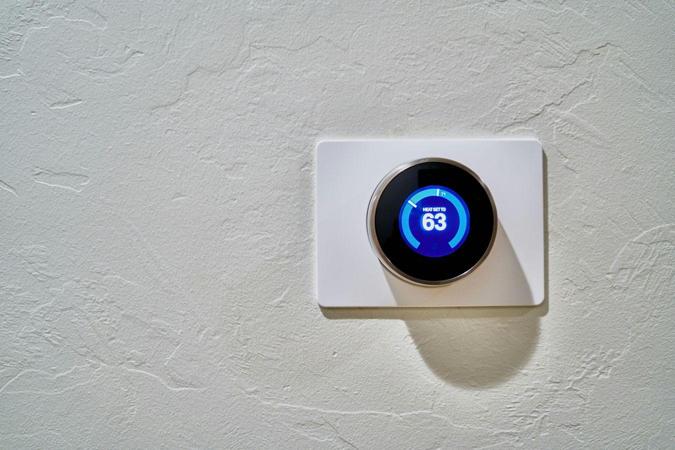 A smart thermostat set to heat a house to 63 degrees Fahrenheit.
