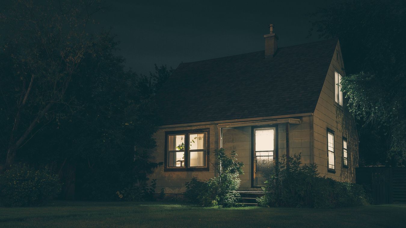 A home with its lights on in the dark.