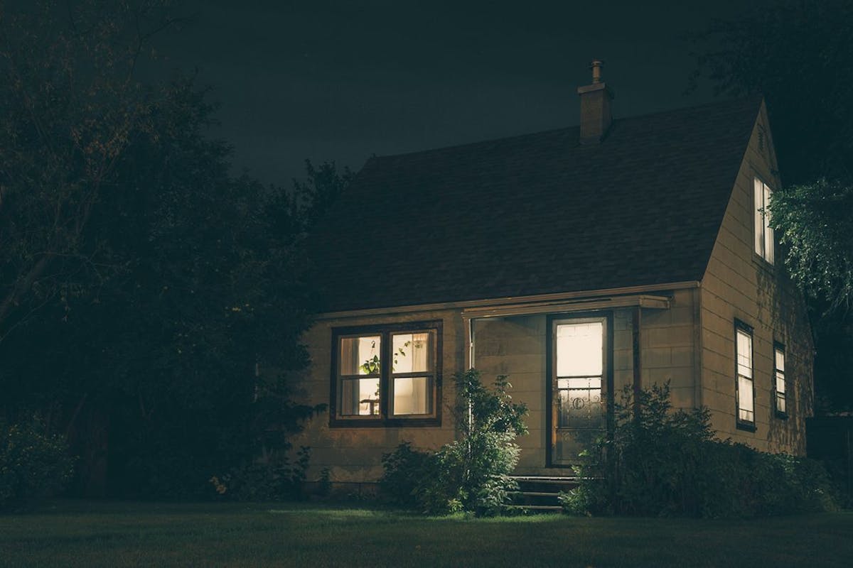 A home with its lights on in the dark.