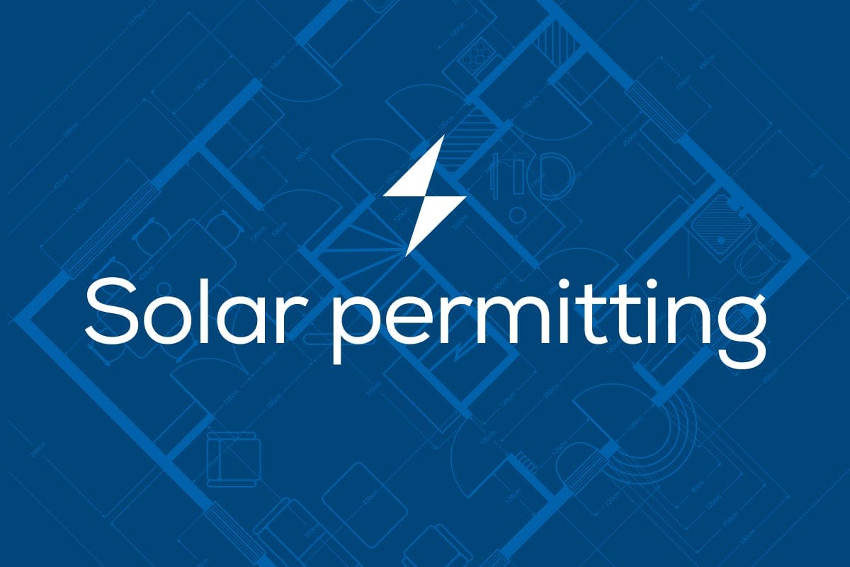 The words "Solar Permitting" on top of a home's blueprint, representing the complex way that local solar permitting impacts the solar panel installation process, including timeline, requirements, and costs.