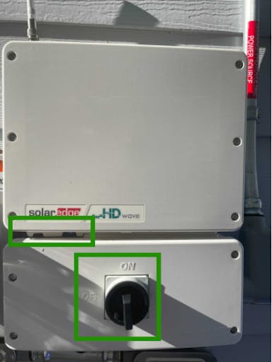 Image of a SolarEdge inverter with squares to highlight both the circular switch and the toggle.