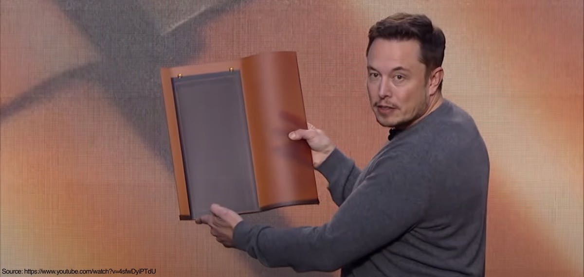 Elon Musk showing an early prototype of the Tesla Solar Roof tile in the Tuscan style.