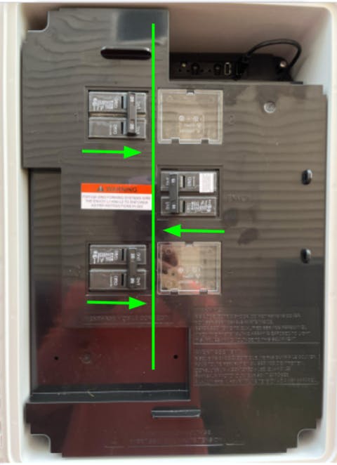 Enphase IQ Combiner open to show breakers with arrows to indicate the center position.