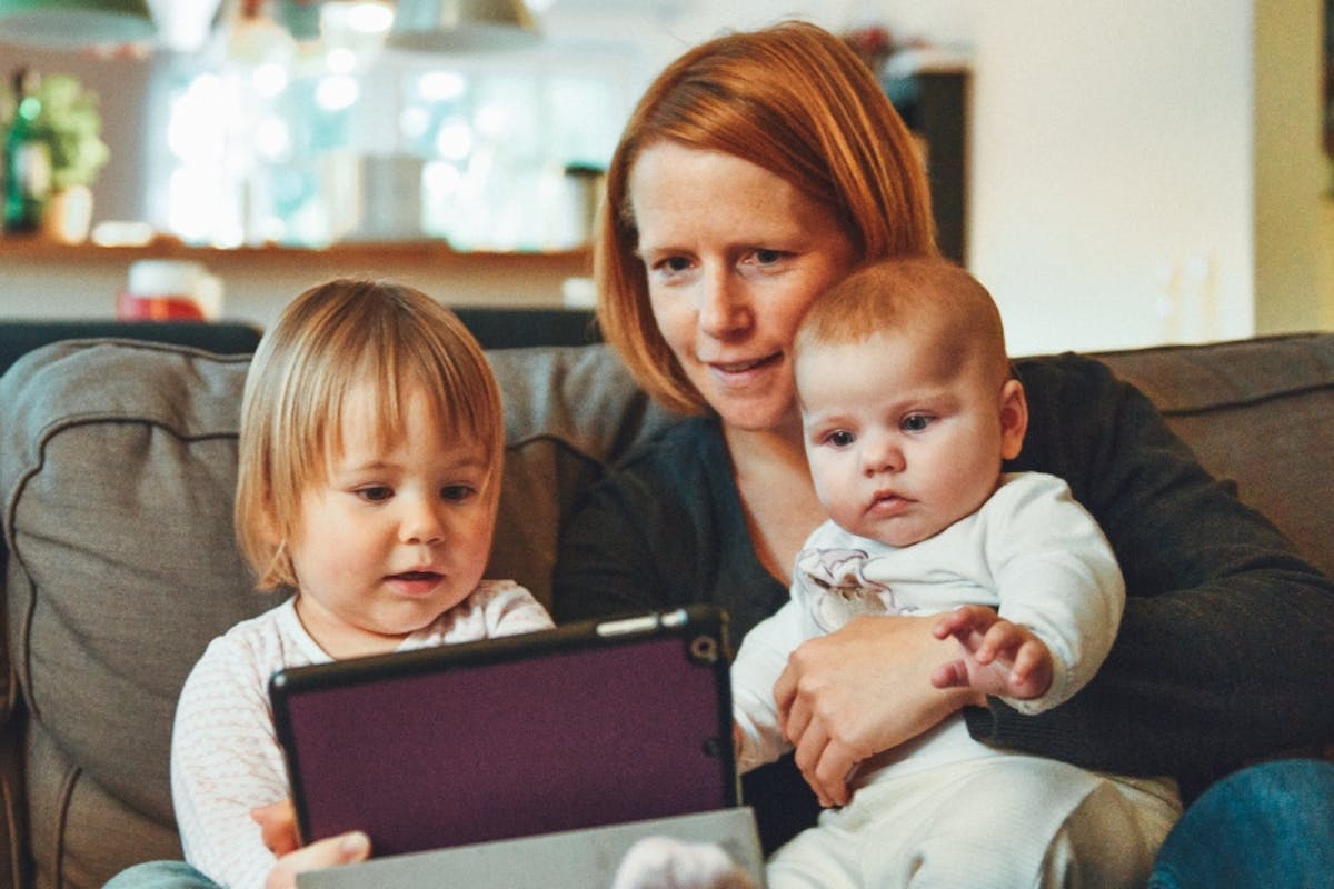 A family sitting comfortably on the couch in their home.