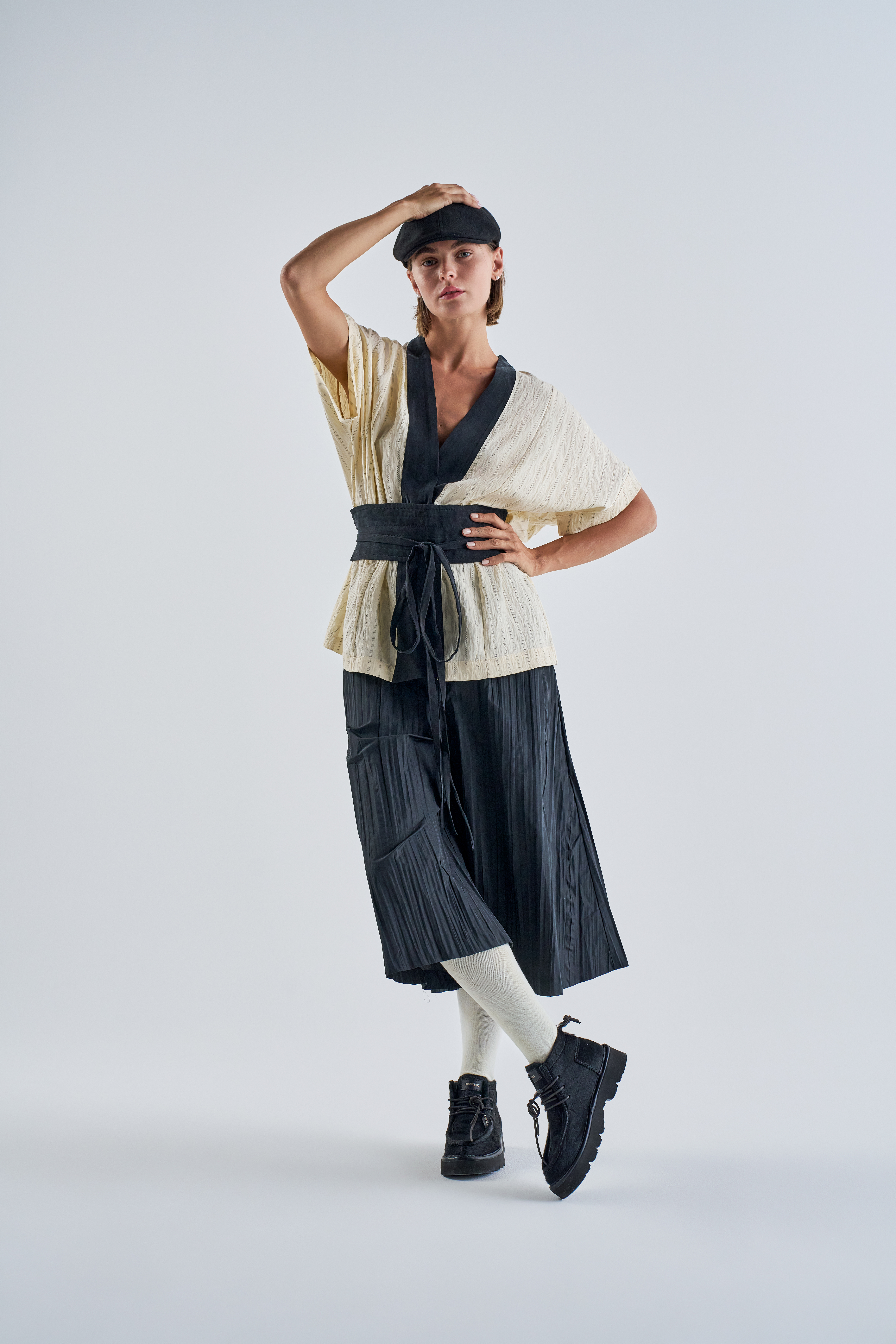 Scatto a figura intera di una modella. Look di ispirazione giapponese, ai piedi indossa un paio di polacchini P009 in cavallino nero.
