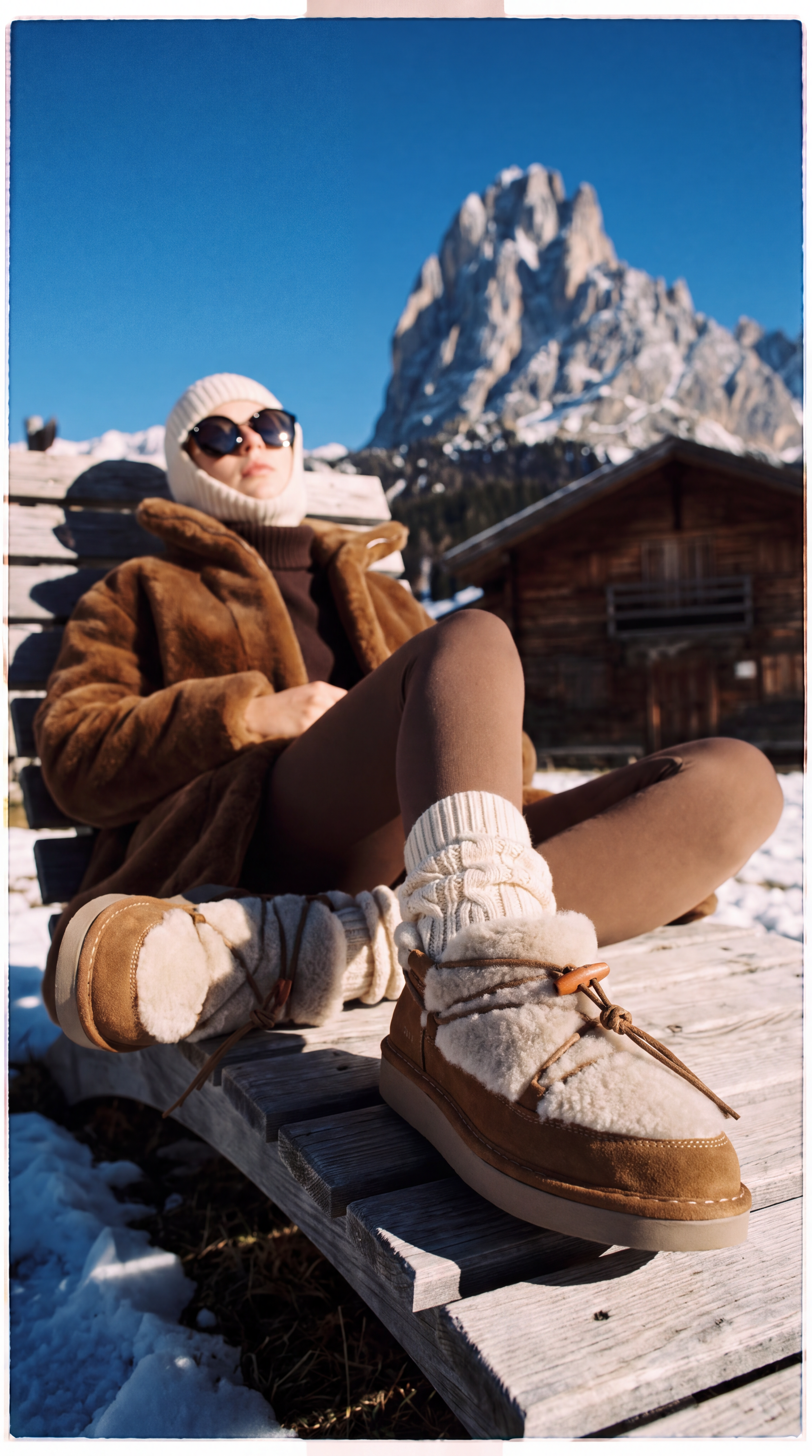 Una modella prende il sole in montagna indossando degli scarponcini in montone di P021.