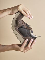 Two hands flex a P005 slip on shoe to show its flexibility.