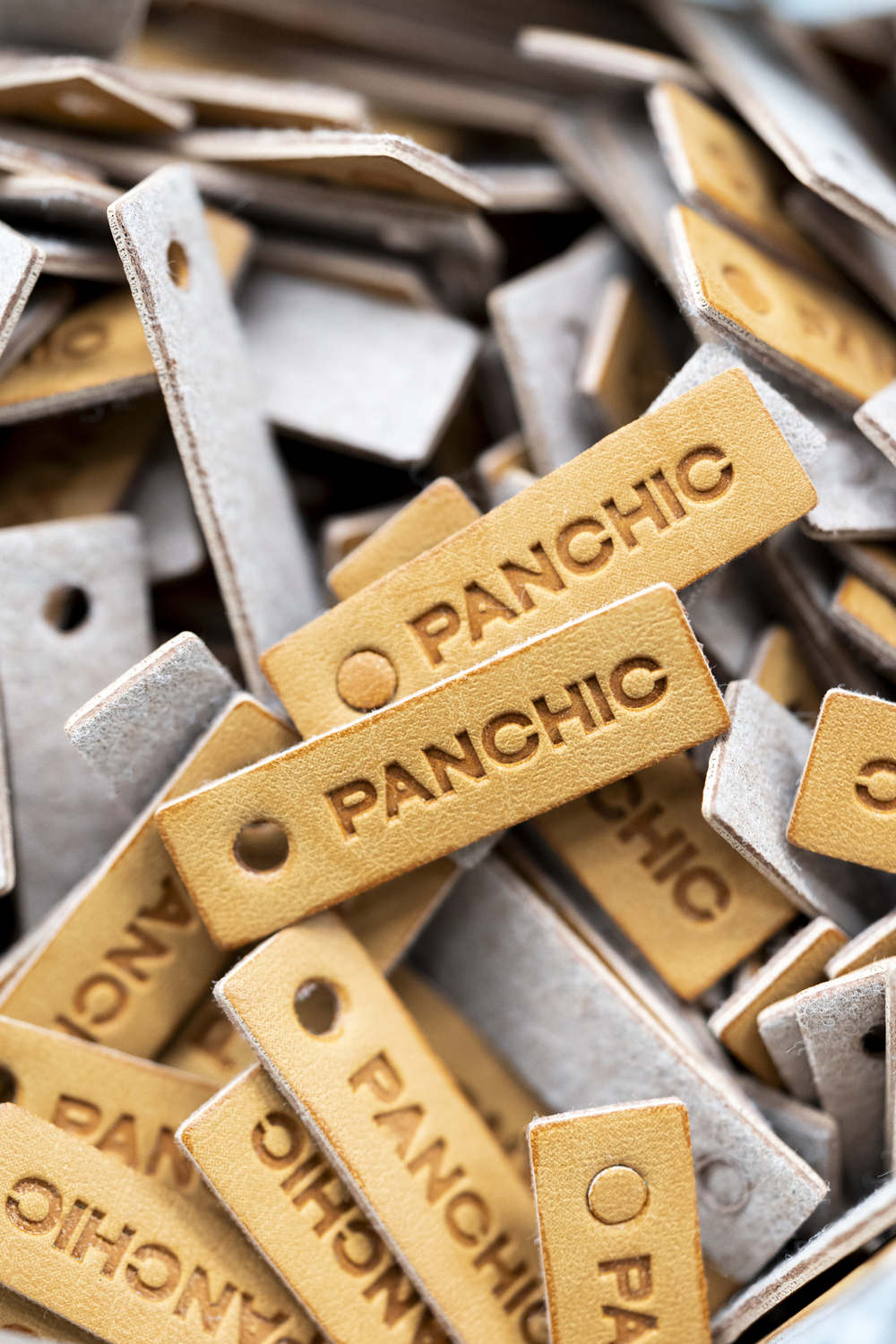 A bunch of leather tags with the logo PANCHIC