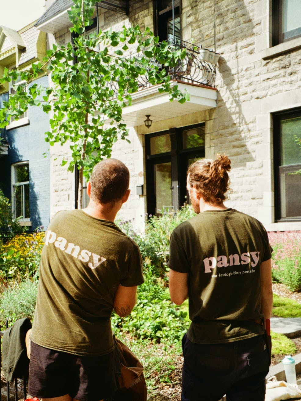 Landscape designers in Pansy shirts working on an eco-friendly front yard garden project.