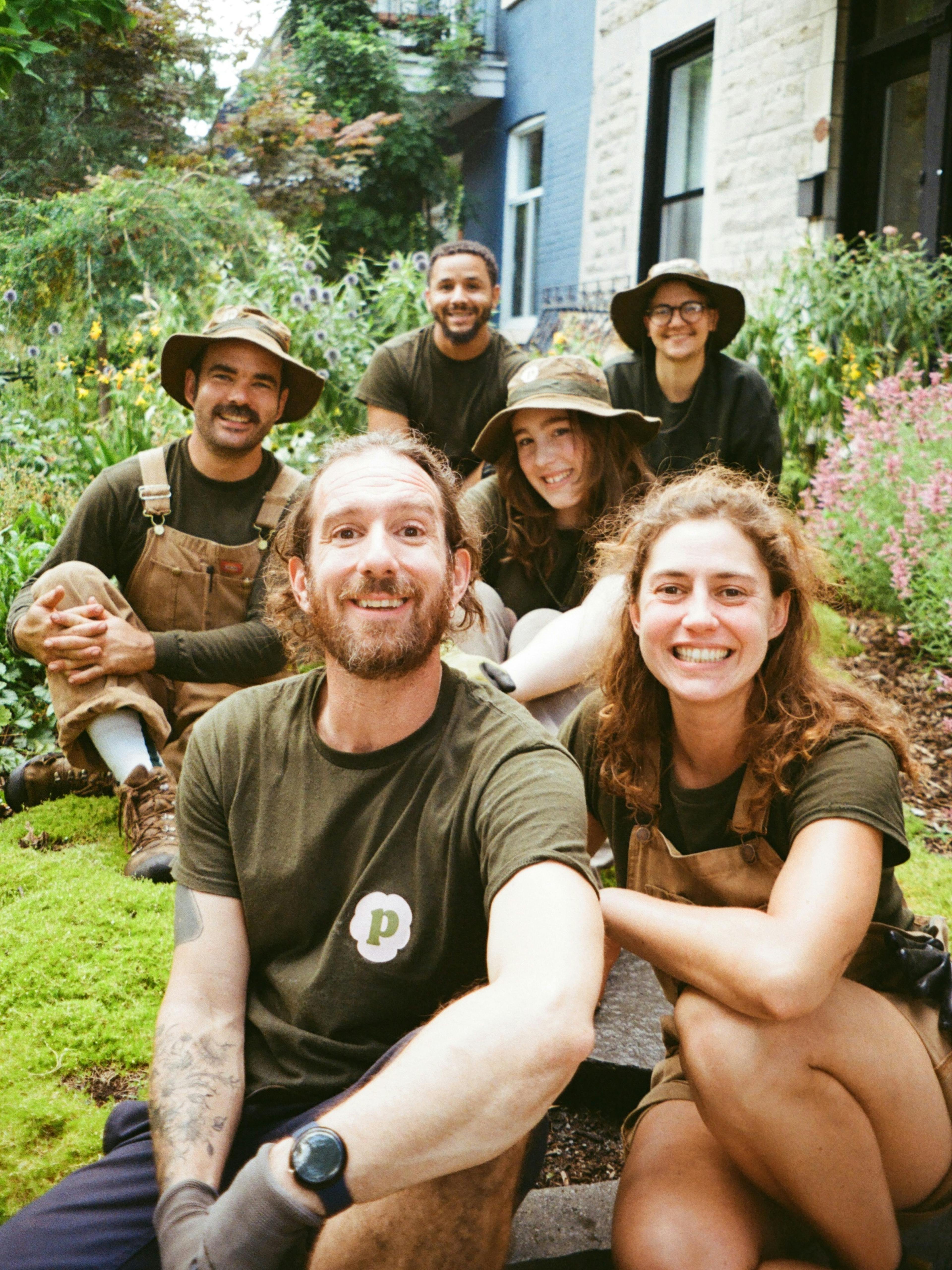 Équipe de concepteurs paysagistes de Pansy souriant ensemble dans un jardin, spécialisés dans les projets écologiques et durables à Montréal.