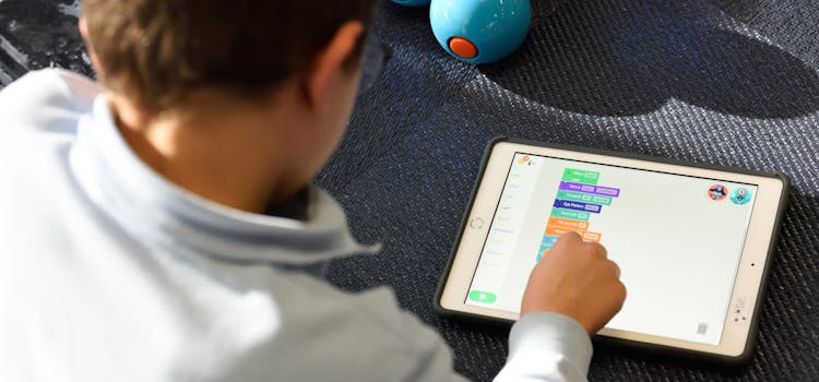 Criança jogando com apps em seu tablet