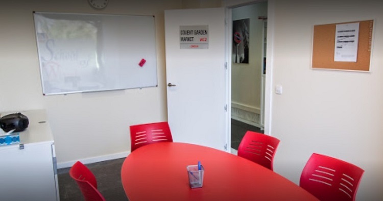 Salones de clases de School of Windsor con mesas y sillas rojas