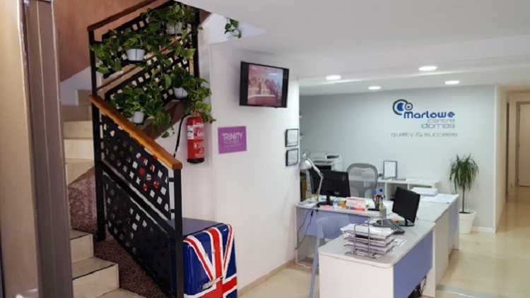 Recepci&oacute;n de Marlowe Centre Idiomas | Sal&oacute;n blanco con mesas blancas y una escaleras a la izquierda.