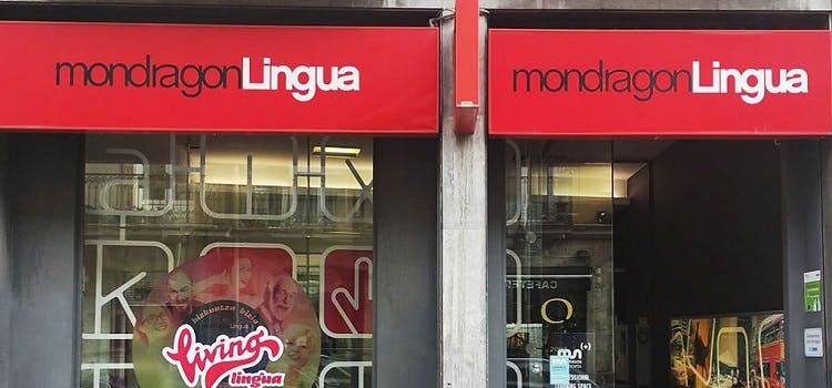 Fachada con cartel rojo del curso de inglés MondragonLingua en Vitoria-Gasteiz.