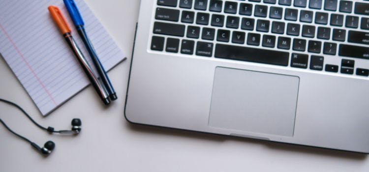 Écouteurs, stylos et ordinateur portable.