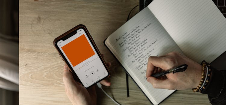 books and cell phone on a table with hand writing
