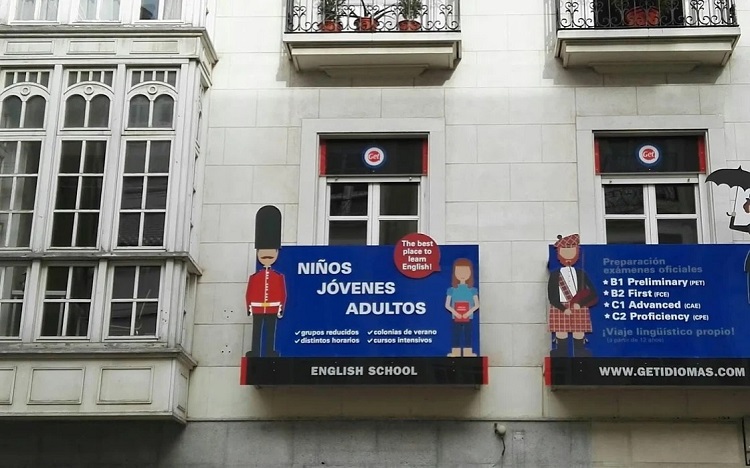 Cartel azul con dibujo de soldados brit&aacute;nicos e informaci&oacute;n sobre el curso de ingl&eacute;s GET IDIOMAS.