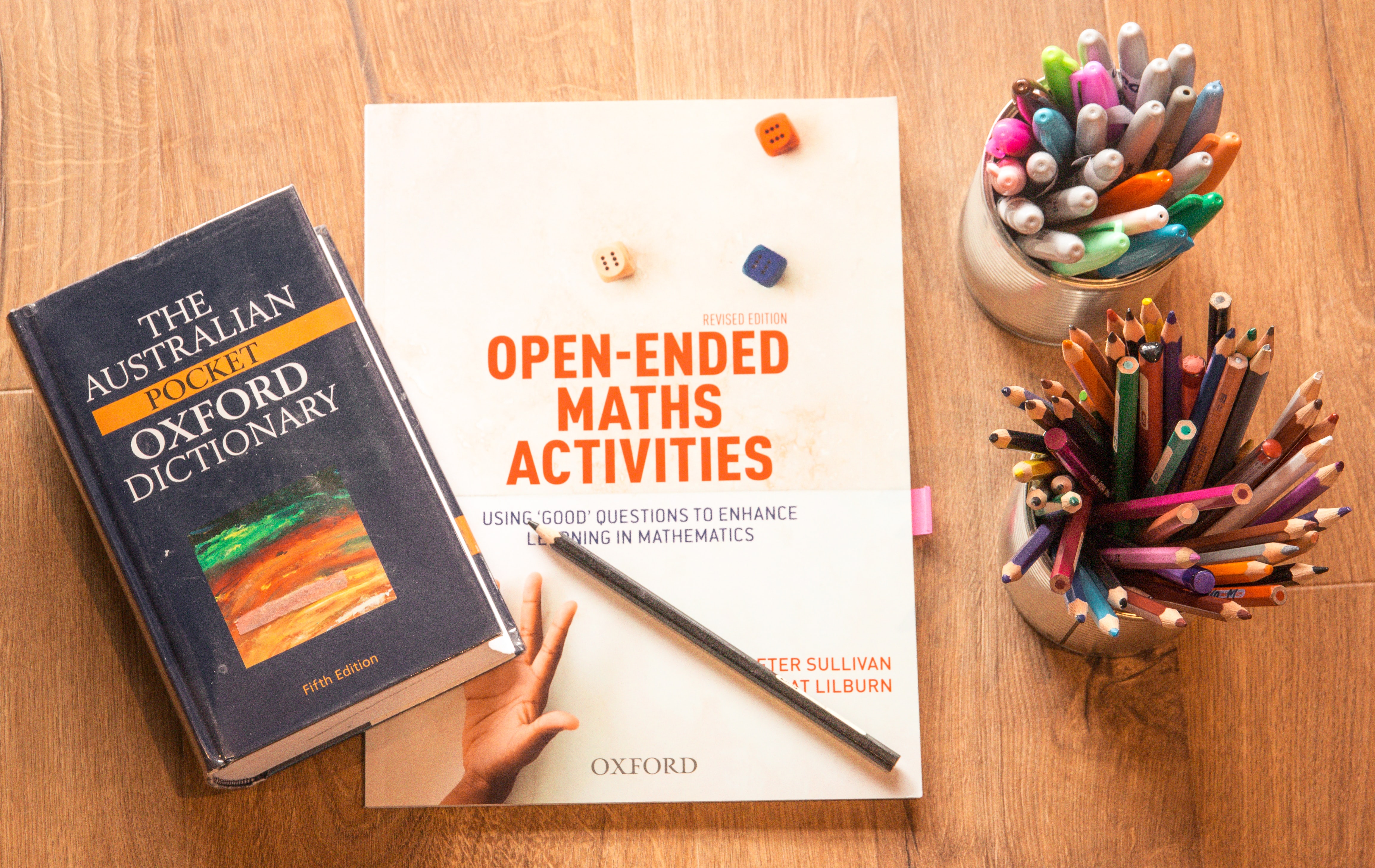 B&uuml;cher und Farben auf einem Holztisch