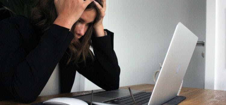 Persona frustrada frente a una laptop