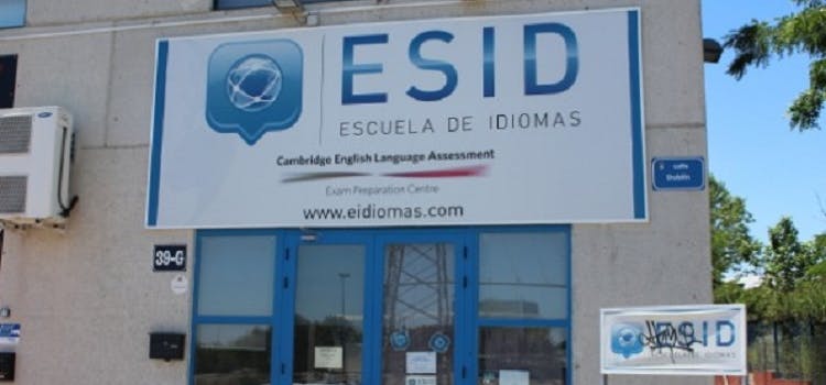 Fachada con puertas azules y un cartel grande que indica "ESID ESCUELA DE IDIOMAS"