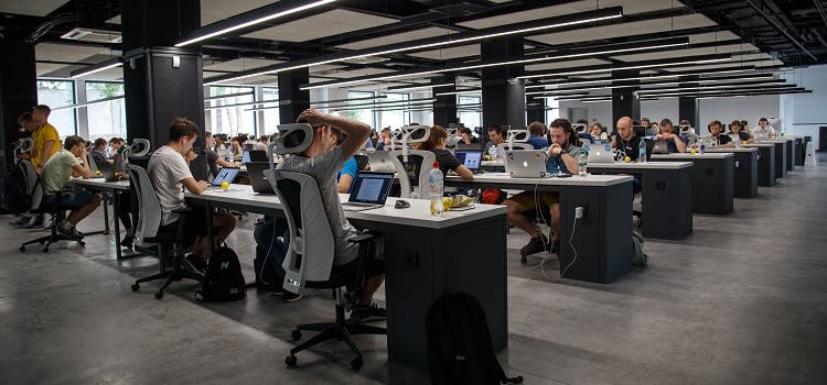 Personas trabajando en oficina con laptop | Cursos para aprender inglés para empresas