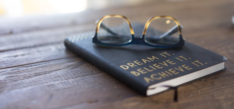libros con gafas sobre una mesa de madera