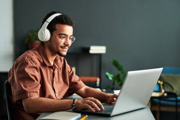 joven estudiando en oficina con audífonos