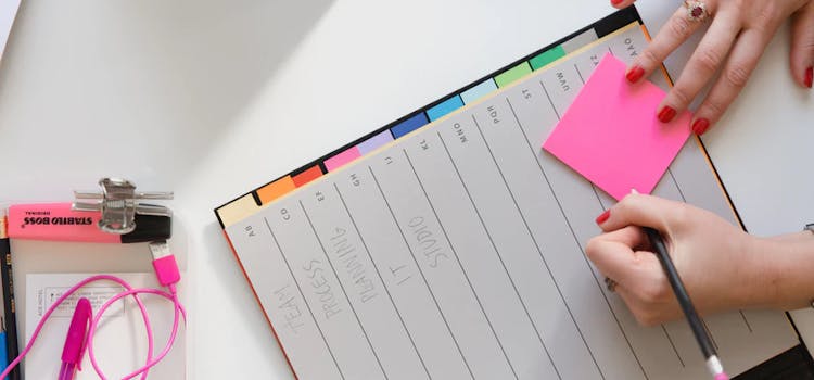 foto de agenda con post its y una mano escribiendo