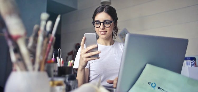 Kobieta w białej koszuli używająca smartfona