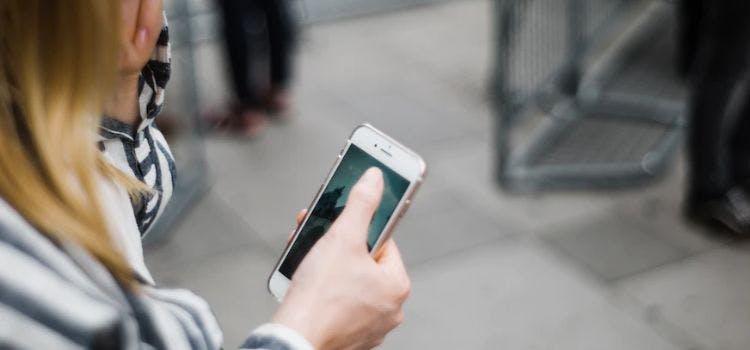 Donna con in mano un telefono cellulare e preoccupata