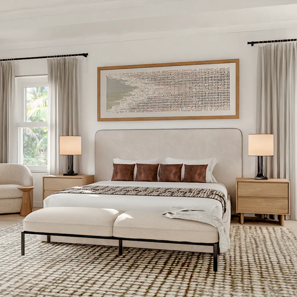 Brightly lit, modern master bedroom featuring a white upholstered king bed, brown accent pillows, a black-framed bench, light wood nightstands, and a patterned rug set against large windows with neutral drapes.