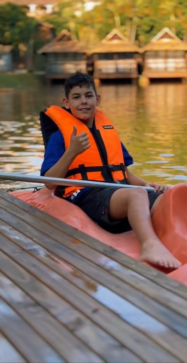 menino em caiaque em lago de hotel fazenda