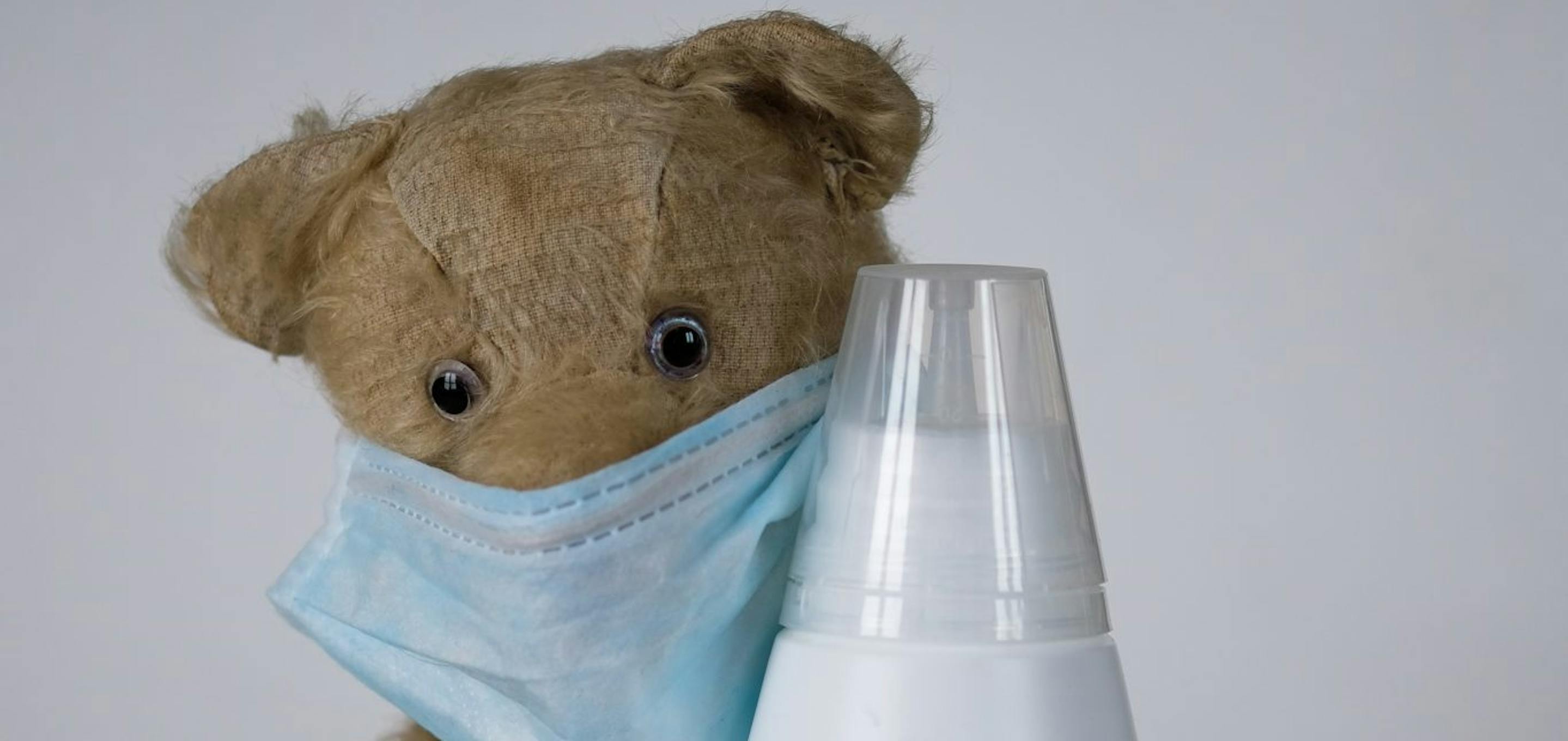 Teddy bear with mask cuddling disinfectant bottle