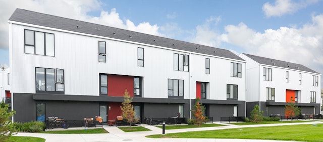 White townhome building with trees outside