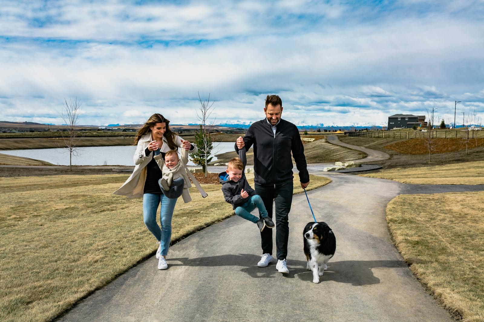 A couple walks a dog and some children down a winding pathway.