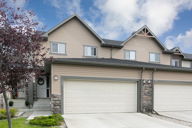 Brown townhome with brick accents and double car garage