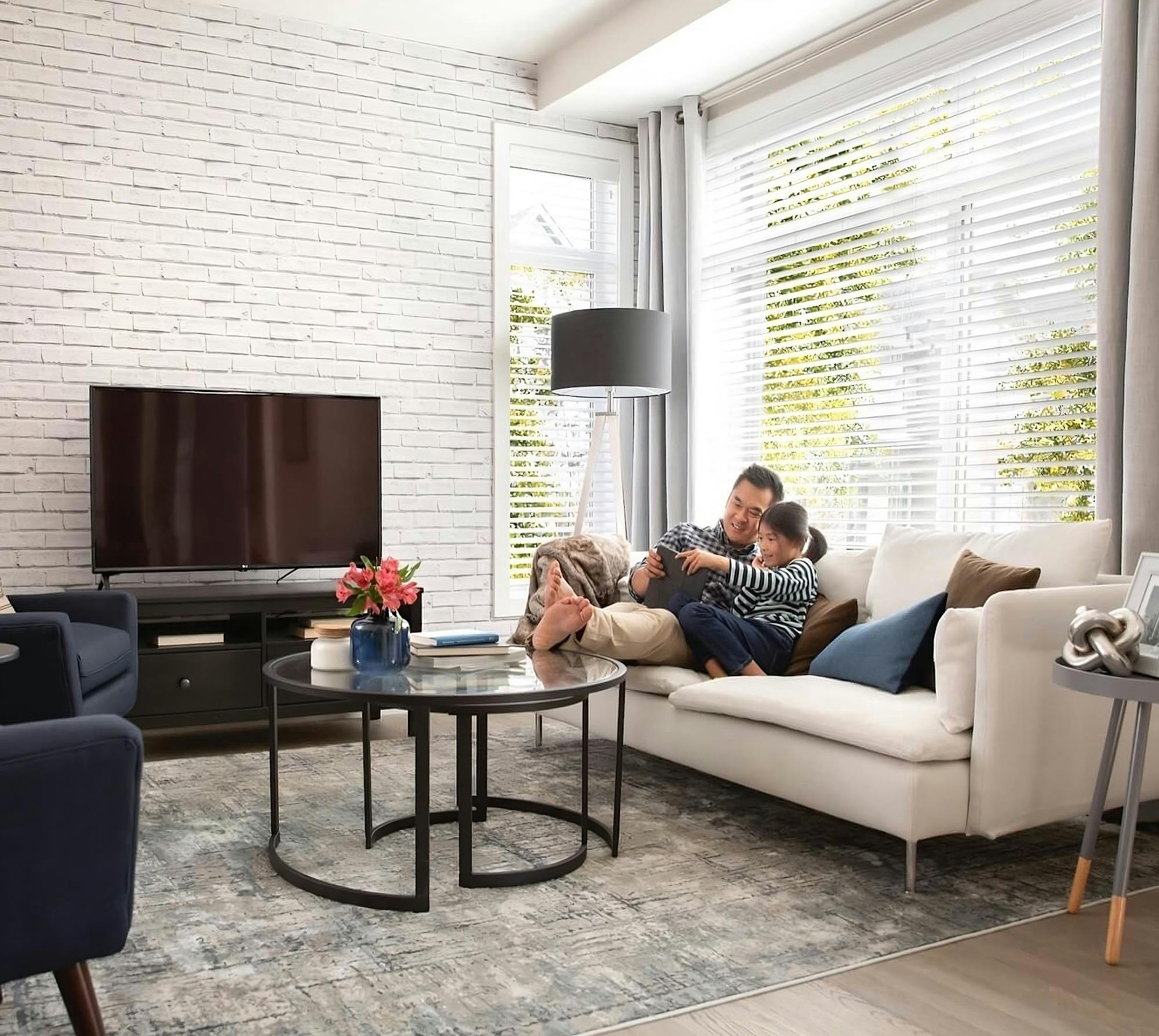 A family enjoying time on the couch in a well-lit living room.
