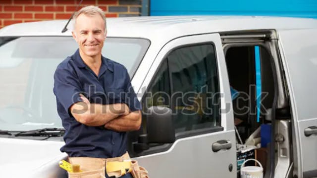 Liam smiling infront of pascoes plumbing van.