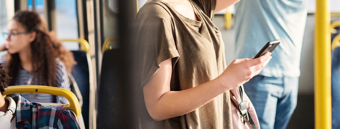 Woman holding phone on the bus.
