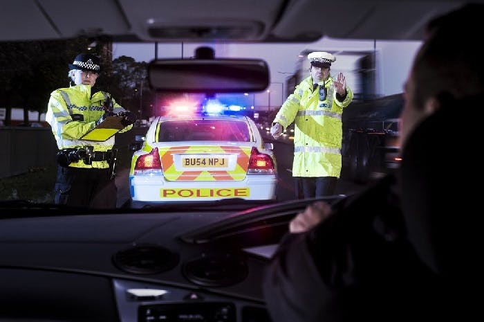 Two UK police officers stopping a speeding car