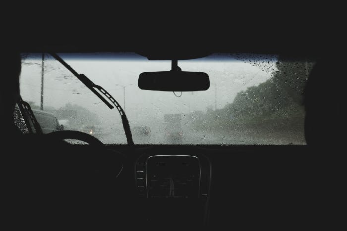 A photograph of a car windshield covered in rain
